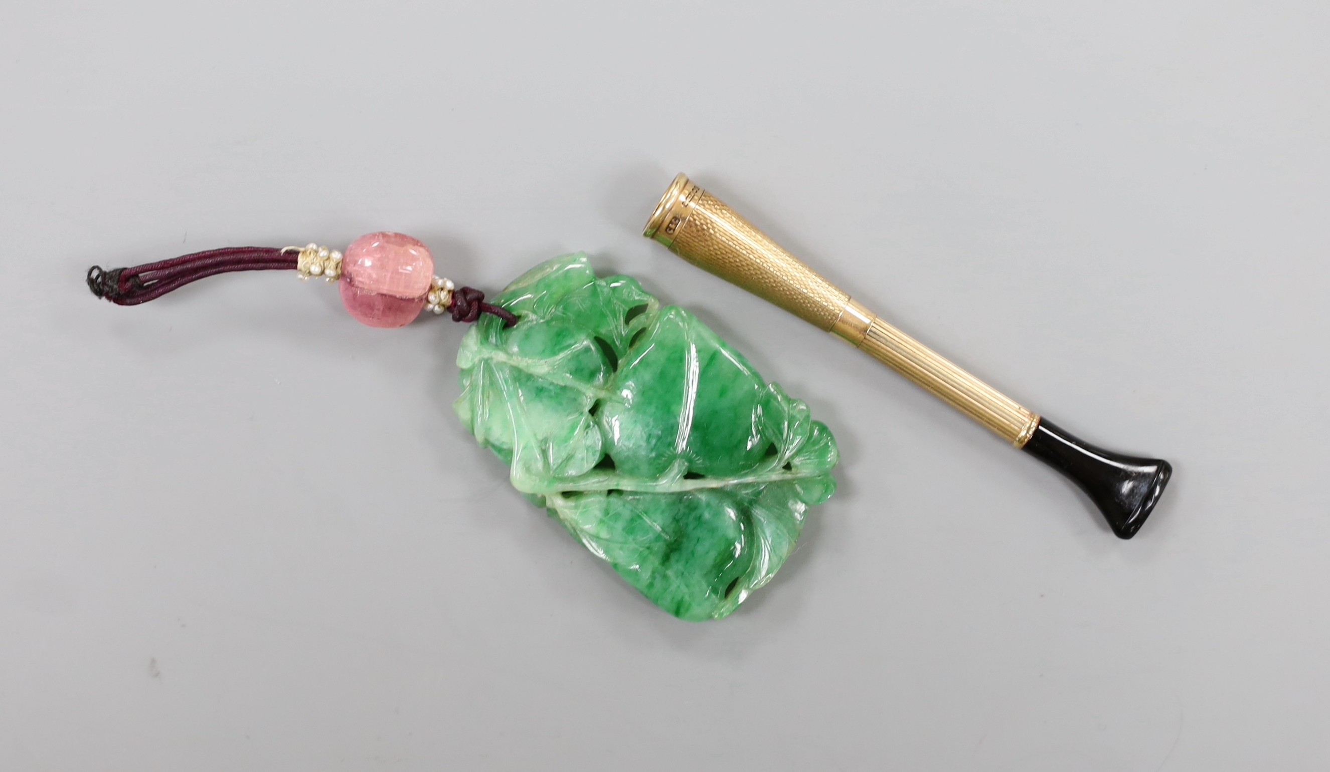 A Chinese carved jadeite pendant and 9ct gold mounted cigarette holder.